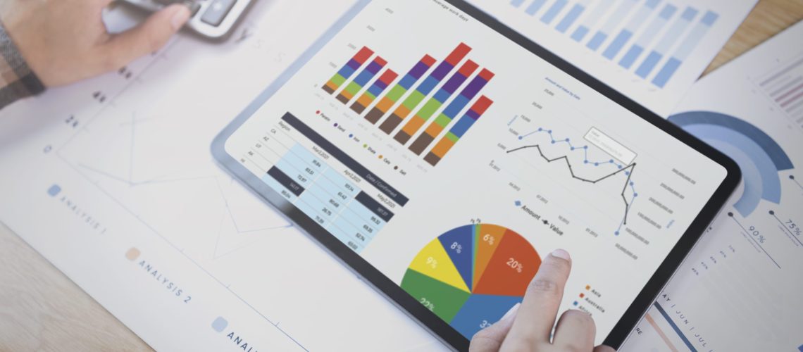 Businesswoman using a tablet to analysis graph company finance strategy statistics success concept and planning for future in office room.